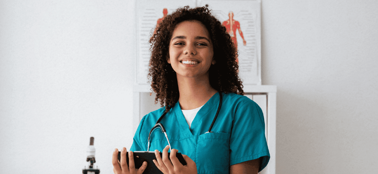 Médico com jaleco segurando estetoscópio em ambiente clínico de avaliação.