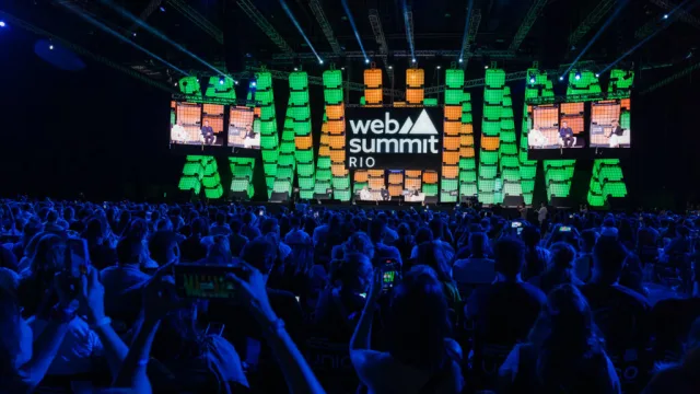 Logotipo do Web Summit Rio em destaque no telão de evento anterior.
