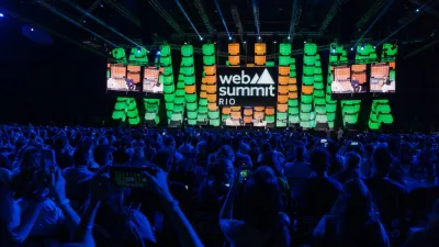 Logotipo do Web Summit Rio em destaque no telão de evento anterior.