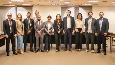 Mesa de reunião entre representantes da Anatel e da OCDE discutindo regulação de tecnologia