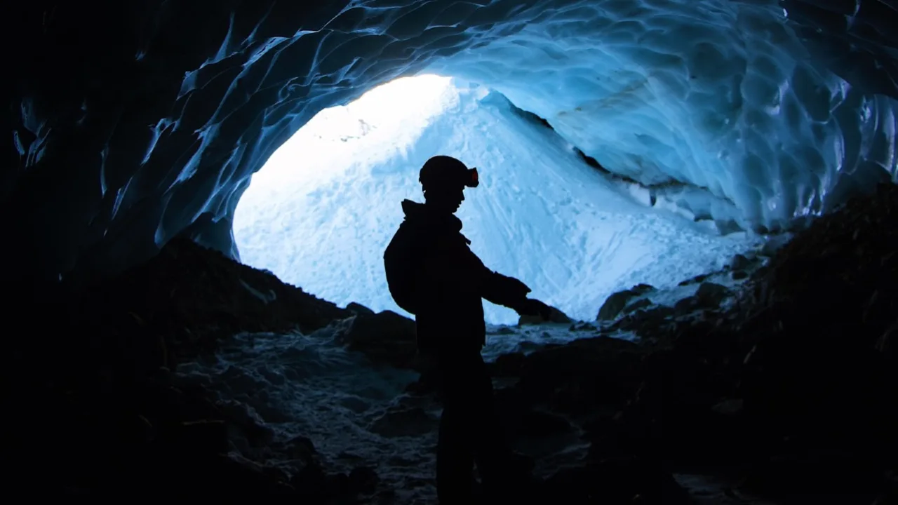 Homem em caverna analisando minerais estratégicos para tecnologia.