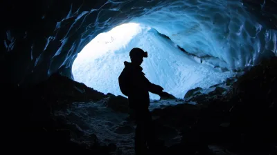 Homem em caverna analisando minerais estratégicos para tecnologia.