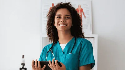 Médico com jaleco segurando estetoscópio em ambiente clínico de avaliação.