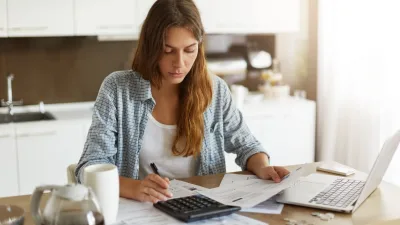 Microempreendedor individual analisando documentos financeiros no computador